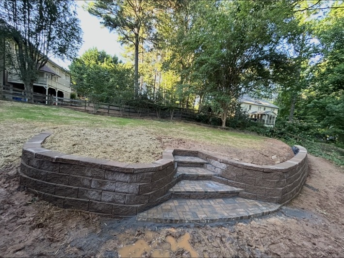 Wide view of a curved block retaining wall and paver steps