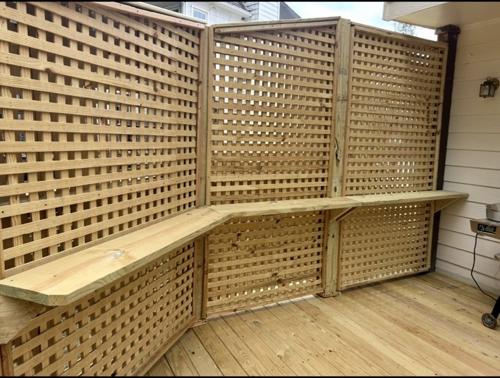 Custom lattice privacy railing with a built-in counter along a wood deck