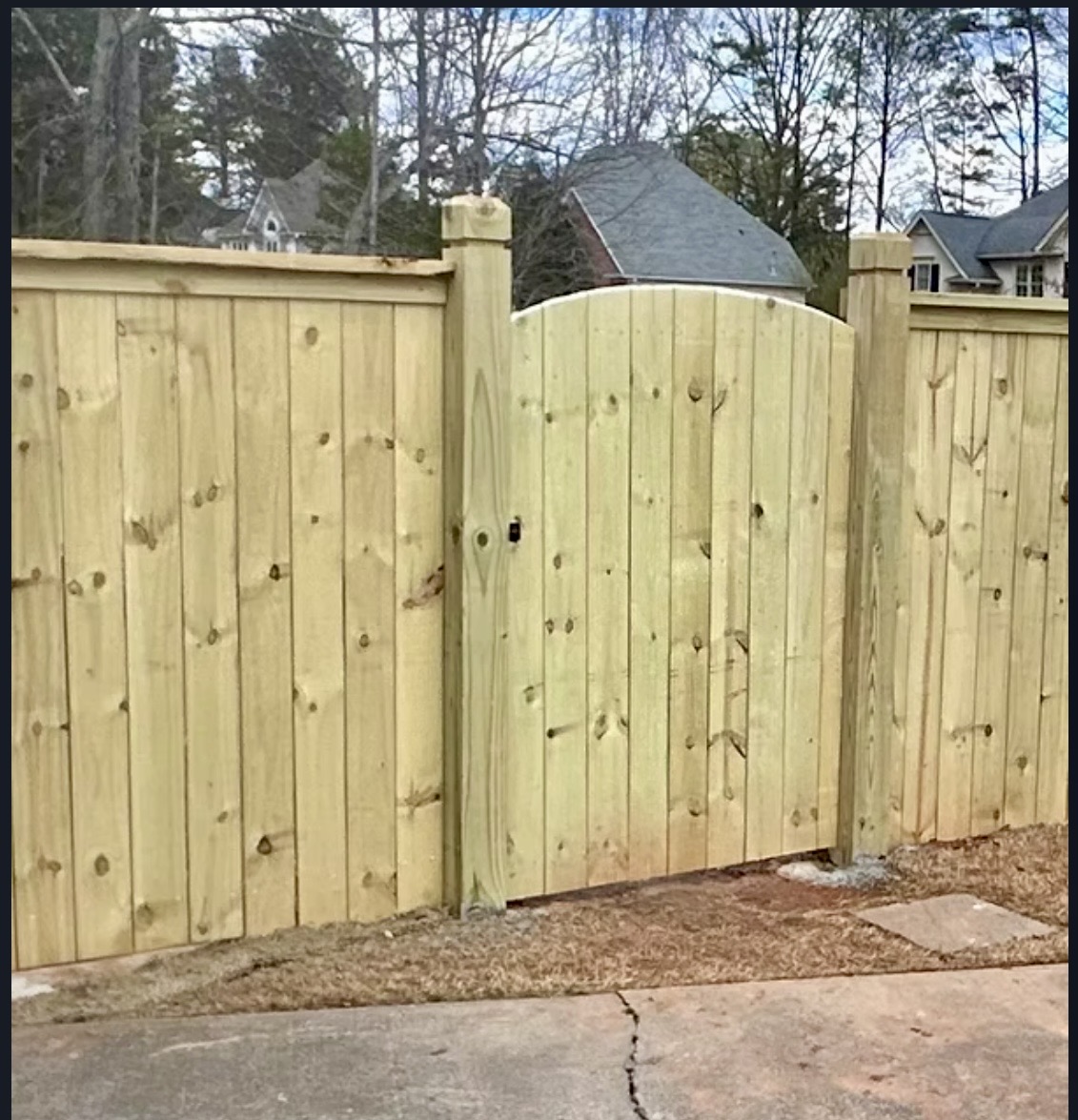 Wood privacy fence with a custom arched-top gate